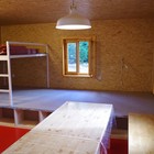 Podium s úložnými prostory a vyvýšené patro určené ke spaní, skládací židle